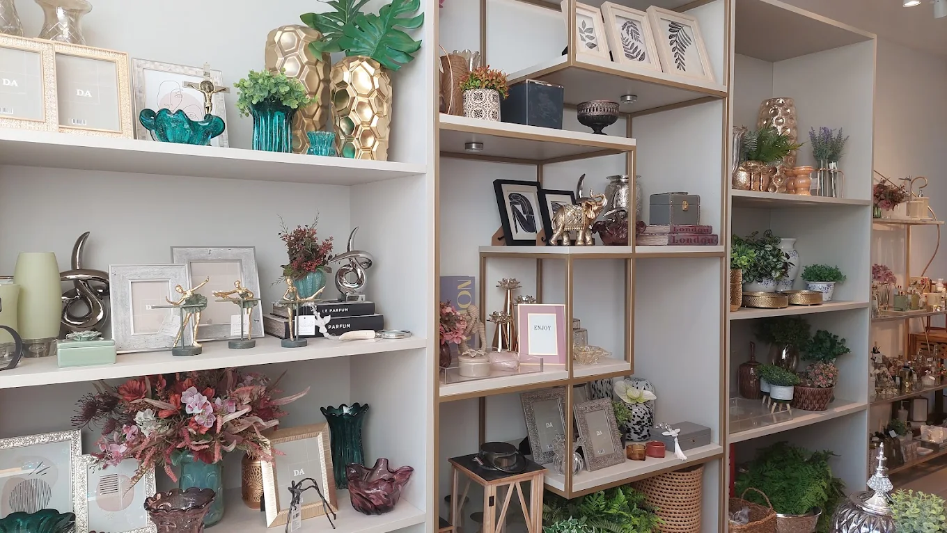 Estante da loja com porta-retratos, vasos e objetos de decoração